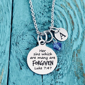 May include: Silver necklace with a round pendant that says "Her sins which are many are FORGIVEN Luke 7:47". The necklace also has a small charm with the letter "A" on it.