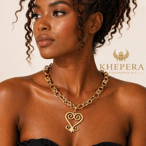 Collar llamativo de eslabones dorados con colgante de corazón Sankofa y cadena de acero inoxidable. Joyería de diseño inspirado en África.