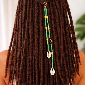 Joyería para rastas de inspiración africana con conchas de cauri, adorno para el cabello con cuentas verdes y detalles dorados, accesorio para rastas de estilo bohemio tribal.