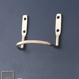 May include: Silver-toned metal hook with two holes on each side. The hook is curved and designed to hold a small object.