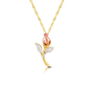 May include: A gold chain necklace with a rose bud pendant. The rose bud is made of gold and has a pink center. The leaves of the rose are silver.