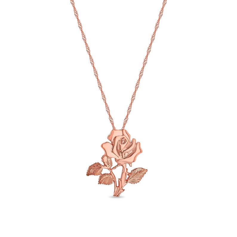 Puede incluir: Un collar de oro rosa con un colgante de rosa. La rosa est&aacute; detallada con hojas y un tallo.