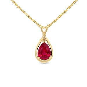 May include: A gold-colored necklace with a teardrop-shaped pendant. The pendant features a vibrant red gemstone, set within a gold frame. The chain is a delicate, twisted design, and the pendant hangs from a small loop.