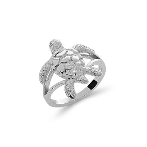 May include: A silver ring featuring a detailed turtle design. The turtle is positioned on top of the ring band, with its head and legs extending out.