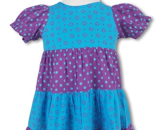 May include: A tiered dress for girls with a blue and purple floral print. The dress has a round neckline and short sleeves.