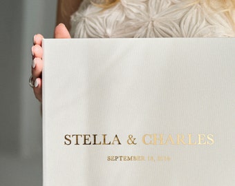 May include: A white wedding album with gold lettering that reads "STELLA & CHARLES SEPTEMBER 18, 2024".