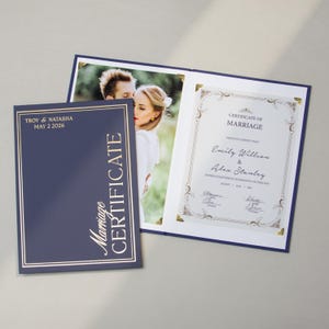 Puede incluir: Un certificado de matrimonio azul marino con letras doradas y un borde dorado. El certificado está abierto, revelando una foto de una pareja y un certificado de matrimonio con detalles dorados ornamentados. El texto dice "Certificado de matrimonio".