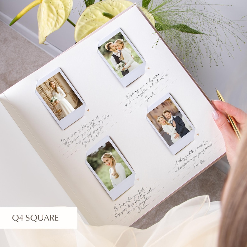 Open ivory wedding guest book in the bride’s hands; four Instax/Polaroid prints arranged in a 2×2 grid using white photo corners, each section with dotted lines and small heart icons for guests’ wishes; gold pen visible and pale green flowers in the scene.