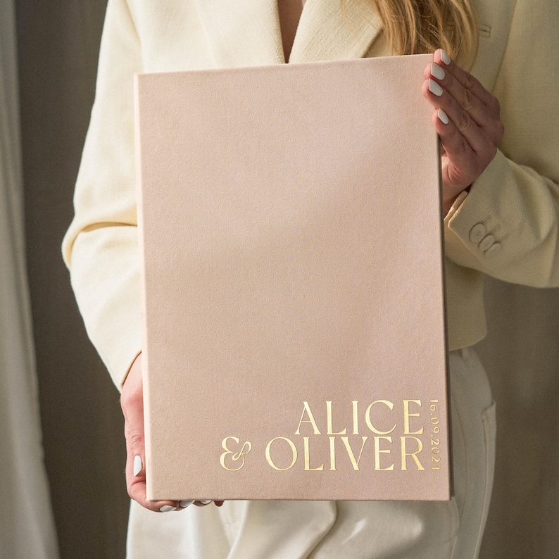 Vertical view of sand-colored slip-in wedding guest book with gold foil personalization ‘Alice & Oliver’, elegant minimalist album design