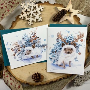 Pack of two greeting cards, hedgehog with fir branches and Christmas decorations. image 1