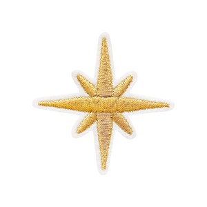 May include: A gold embroidered star with eight points, on a white background. The star is a popular symbol of Christmas and the holiday season.
