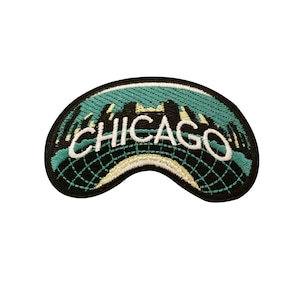 May include: A green and black embroidered patch with the word "CHICAGO" in white lettering. The patch features a stylized cityscape design.