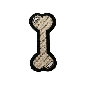 May include: A white embroidered bone-shaped patch with a black outline.