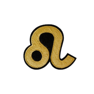 May include: Gold embroidered zodiac symbol for Leo, the lion, with a black outline.