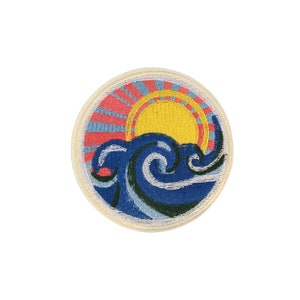 May include: A round embroidered patch with a blue wave and a yellow sun with red and pink rays. The patch is on a white background.