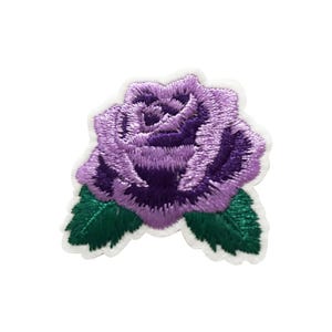 May include: Embroidered patch featuring a purple rose with green leaves. The rose has detailed stitching in shades of purple, with a white border. The leaves are a deep green color. This patch is suitable for clothing or accessories.