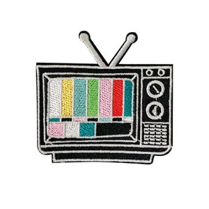 May include: A black and white embroidered patch of a vintage television with a static screen. The screen is filled with colorful bars, reminiscent of a television signal.