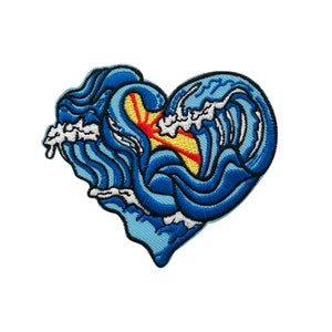 May include: Blue and white embroidered patch shaped like a heart with a red and yellow sun inside of the waves.