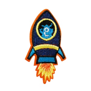 May include: A blue and orange embroidered rocket patch with a yellow flame and a blue alien inside the rocket.