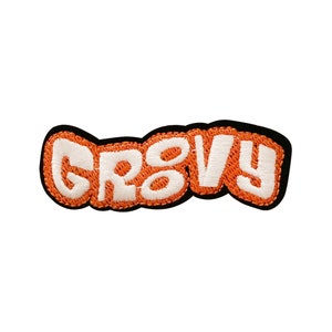 May include: Orange and white embroidered patch with the word "Groovy" in a retro font.