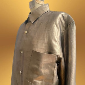 K&ouml;nnte beinhalten: Ein lang&auml;rmliges Hemd mit Kn&ouml;pfen in metallischem Silber mit einer einzigen Tasche auf der linken Seite.