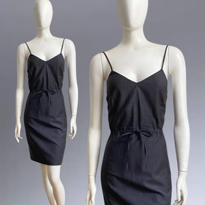May include: A black and white striped spaghetti strap dress with a drawstring waist.