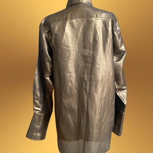 K&ouml;nnte beinhalten: Ein lang&auml;rmliges, metallisch goldenes Hemd mit Knopfleiste und leicht lockerer Passform.