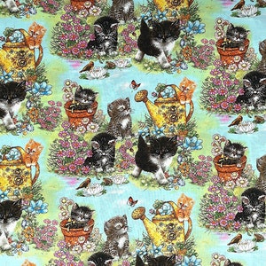 May include: A blue and green fabric with a repeating pattern of black and white kittens holding watering cans and flowers. The kittens are surrounded by flowers and leaves.