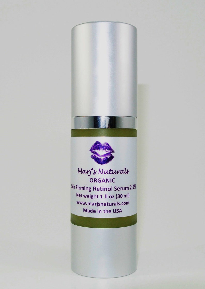 May include: A silver and green bottle of Marj's Naturals Organic Skin Firming Retinol Serum 2.5%. The label features a purple lip design and the text "Net weight 1 fl oz (30 ml)". The product is made in the USA.