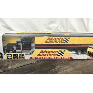 May include: A remote control semi-truck toy in a box. The truck is black with a yellow trailer featuring "Advance Auto Parts" branding. The box includes a remote control and is marked for ages 6+.
