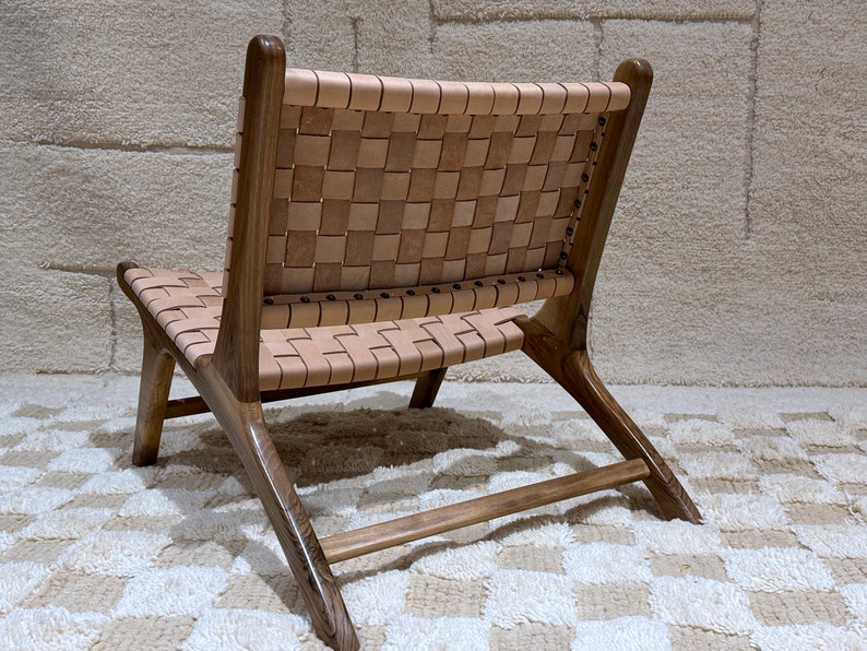 May include: A brown wooden chair with a woven leather seat and back. The chair has a simple, modern design and is ideal for a living room or dining room.
