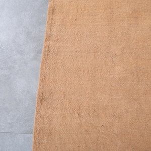 May include: A close-up of a brown doormat with a textured surface.