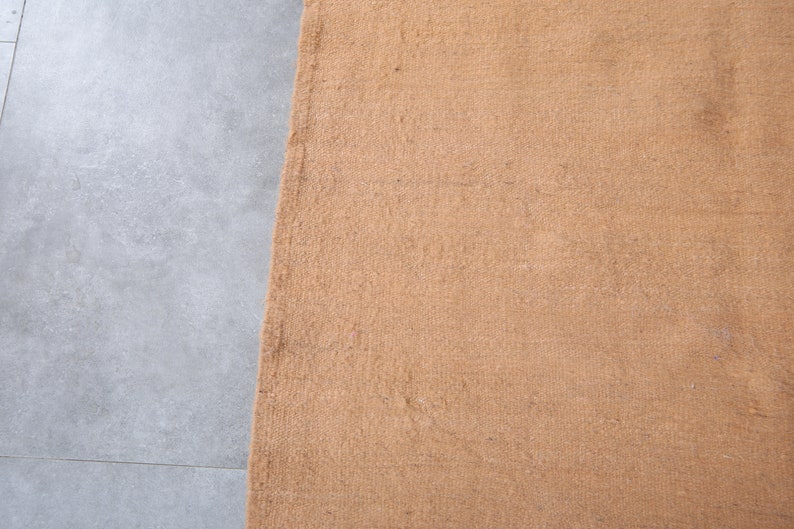 May include: A close-up of a brown doormat with a textured surface.