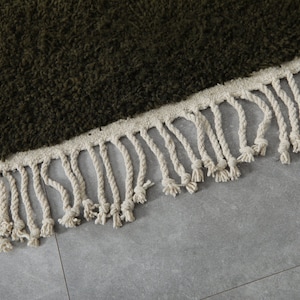 May include: A dark green shag rug with a white fringe border.