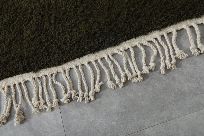 May include: A dark green shag rug with a white fringe border.