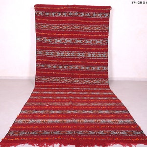Può includere: Un tappeto marocchino rosso e arancione con motivi geometrici. Il tappeto misura 171 cm x 425 cm, ovvero 4,6 piedi x 13,9 piedi. Il tappeto ha una frangia alle estremità.