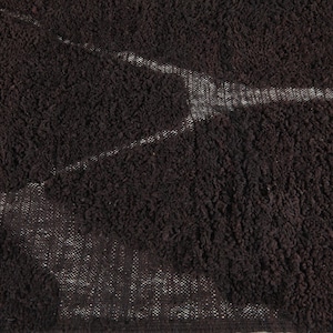 May include: Close-up of a dark brown, textured fabric with a pattern of lighter, white-toned areas. The fabric has a dense, looped pile, creating a soft, plush appearance. The lighter areas create a subtle, abstract design.