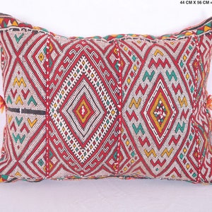 May include: Red, white, green, and yellow geometric patterned throw pillow with tassels. The pillow is 17.3 inches by 22 inches.