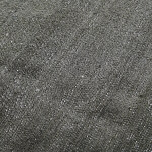 May include: Close-up of a dark grey textured fabric with a subtle woven pattern.