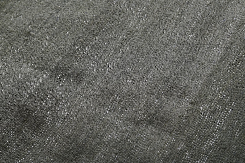 May include: Close-up of a dark grey textured fabric with a subtle woven pattern.