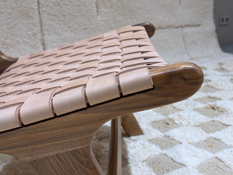 May include: A wooden chair with a woven leather seat. The chair has a dark brown finish and the leather is a light brown colour.