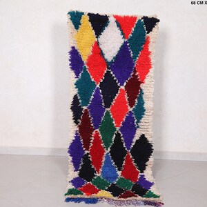 May include: A long, narrow rug with a white background and a colorful diamond pattern. The diamonds are in shades of red, blue, green, yellow, and black. The rug is 68 cm x 180 cm, or 2.2 ft x 5.9 ft.