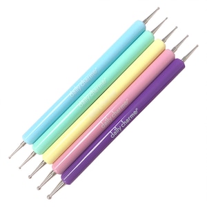 May include: Set of five pastel-colored nail art tools with a silver ball tip. The tools are labeled "daily charmer" in white lettering.