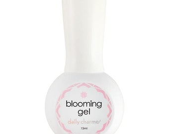 May include: A white bottle of blooming gel nail polish with a pink and white label that says "blooming gel daily charmer 15ml".