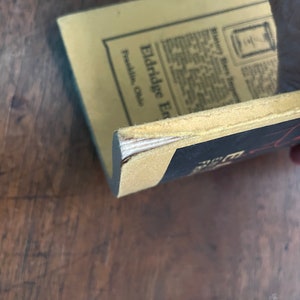 May include: A vintage book with a yellow cover and black text. The title of the book is "Eldridge Enterprises" and the text on the cover says "Franklin, Ohio".