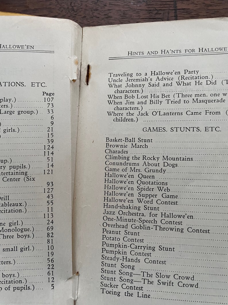 May include: A black and white printed page with the title "Hints and Ha'nts for Hallowe'en" and a list of games and stunts for a Halloween party. The list includes "Basket-Ball Stunt", "Brownie March", "Charades", "Climbing the Rocky Mountains", "Conundrums About Dogs", "Game of Mrs. Grundy", "Hallowe'en Queen", "Hallowe'en Quotations", "Hallowe'en Spider Web", "Hallowe'en Supper Game", "Hallowe'en Word Contest", "Hand-shaking Stunt", "Jazz Orchestra, for Hallowe'en", "One-Minute-Speech Contest", "Overhead Goblin-Throwing Contest", "Peanut Stunt", "Potato Contest", "Pumpkin Contest", "Pumpkin-Carrying Stunt", "Stunt Song", "Steady-Hands Contest", "Stunt Song - The Slow Crowd", "Stunt Song - The Swift Crowd", "Sucker Contest", "Toeing the Line".