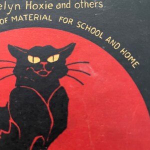 May include: A vintage book cover with a black cat silhouette against a red background. The title is "Halloween" in gold lettering. The text "Elyn Hoxie and others" is below the title. The text "of material for school and home" is below the cat. The text "Price 40 cts" is at the bottom of the cover.
