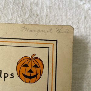 May include: A vintage Halloween card with an orange pumpkin with a black smiling face. The card has a black border and the text "Helps" and "For" are visible. The card is signed "Margaret Kennard".