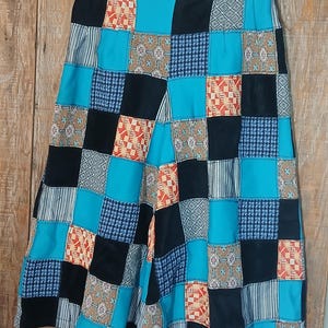 May include: A pair of patchwork culottes with a mix of black, blue, orange, and white patterns. The culottes are made of a variety of fabrics and have a wide leg.