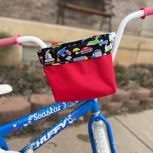 May include: A blue children's bicycle with white handlebars, a red and black handlebar bag, and the words "Seastar" and "HUFFY" on the frame.